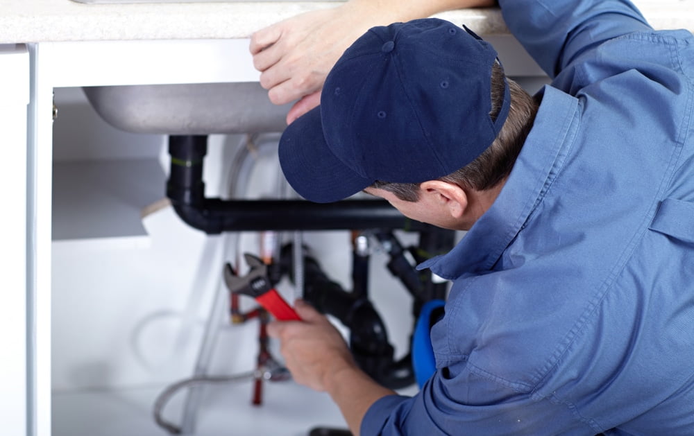 A plumber repairs a sink
